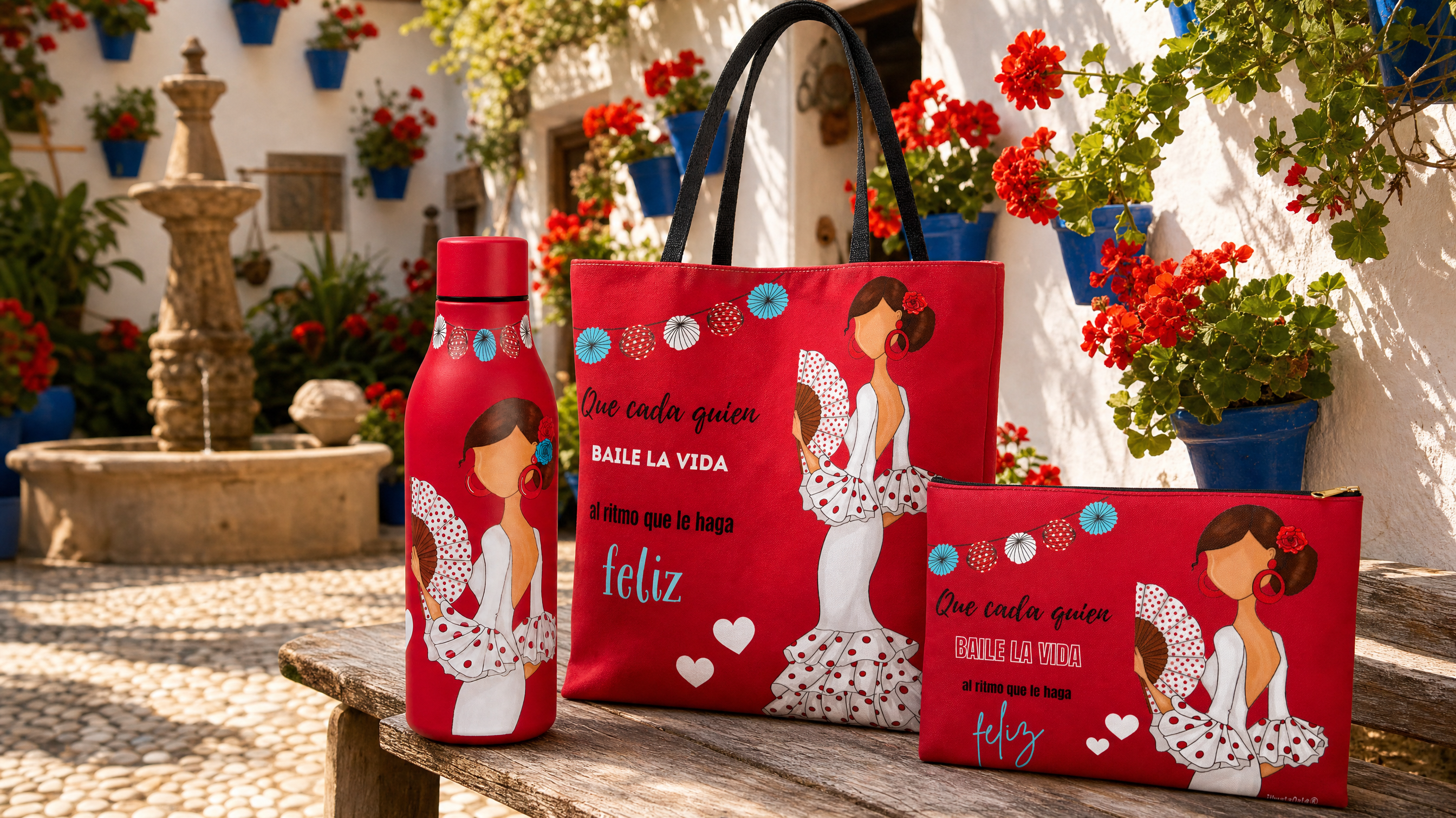 Botella térmica, bolsa tote y neceser flamencos de illustrArte sobre un banco en un patio cordobés con macetas azules y geranios rojos