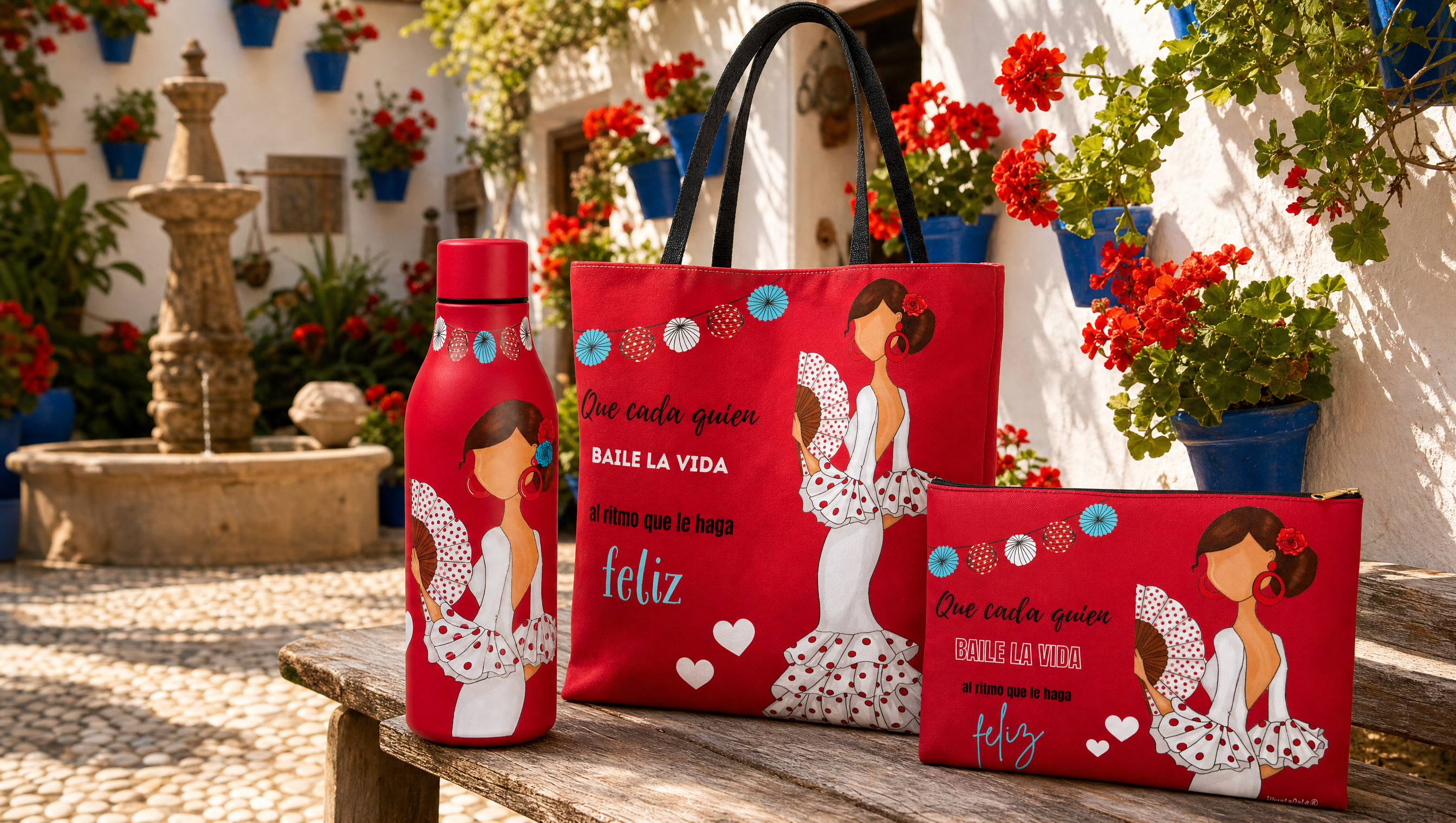 Botella térmica, bolsa tote y neceser flamencos de illustrArte sobre un banco en un patio cordobés con macetas azules y geranios rojos