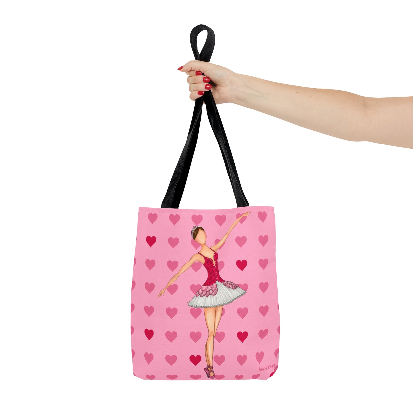 a woman's hand holding a pink tote bag with a picture of a