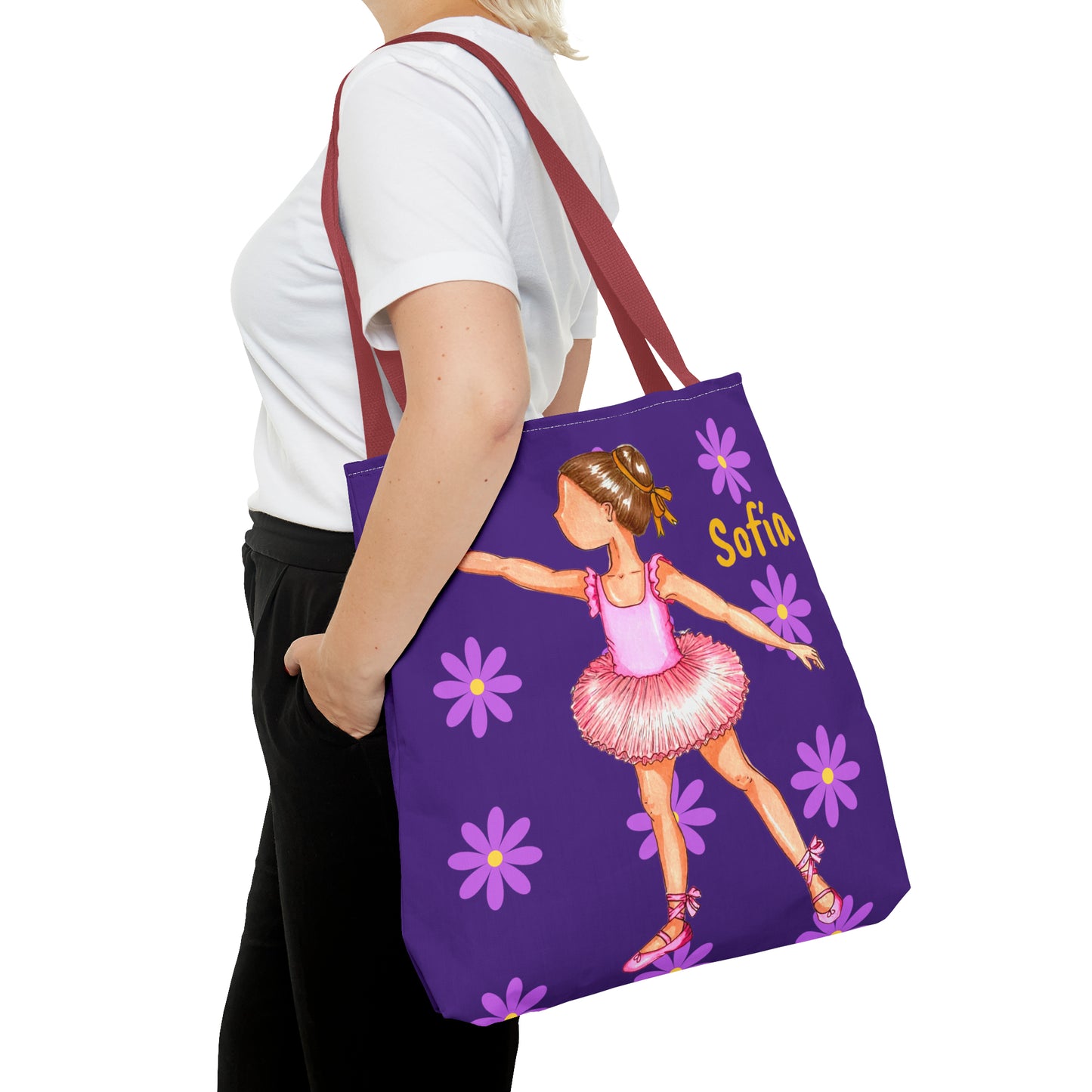 a woman carrying a purple tote bag with a picture of a ballerina