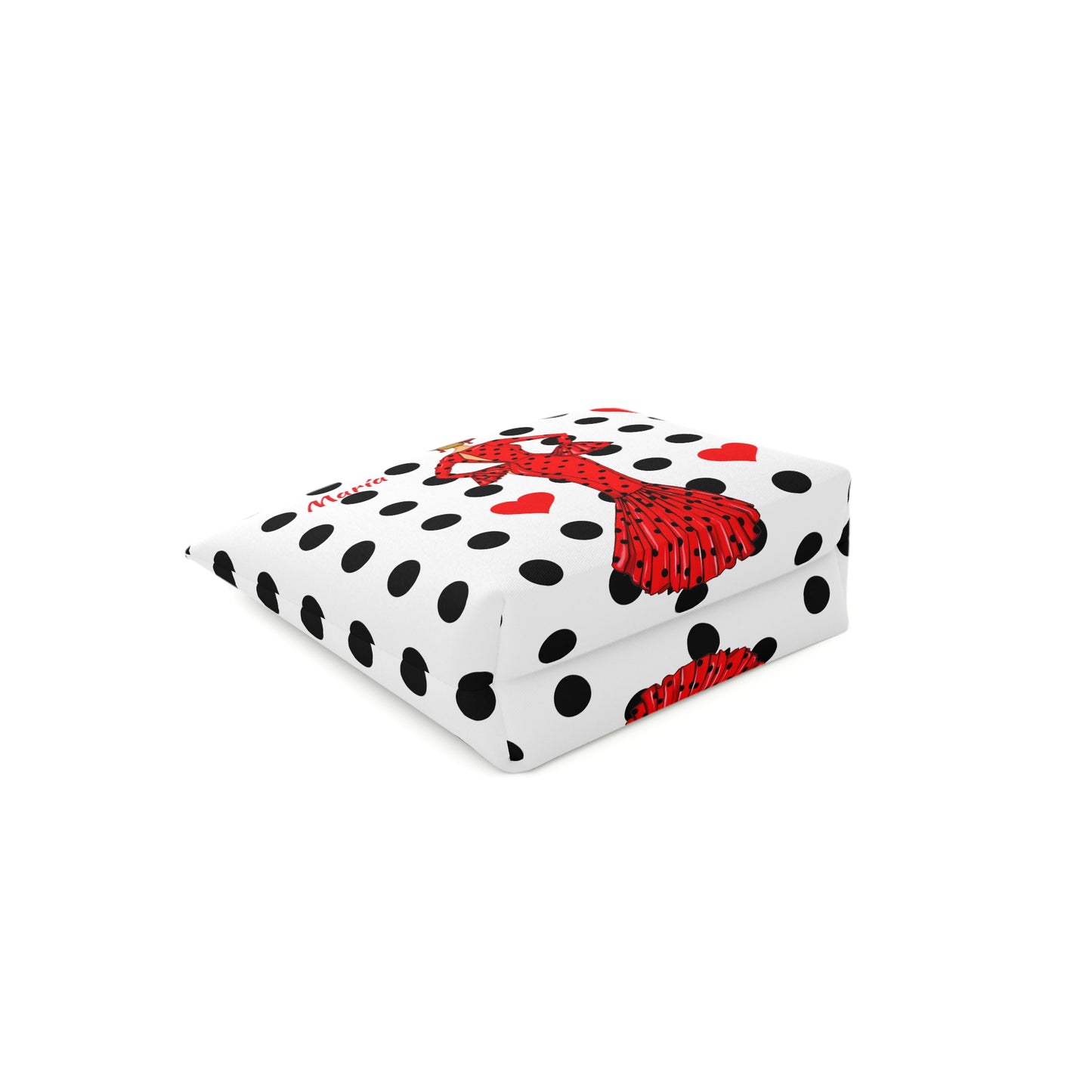 a white and black polka dot blanket with a red bow on it