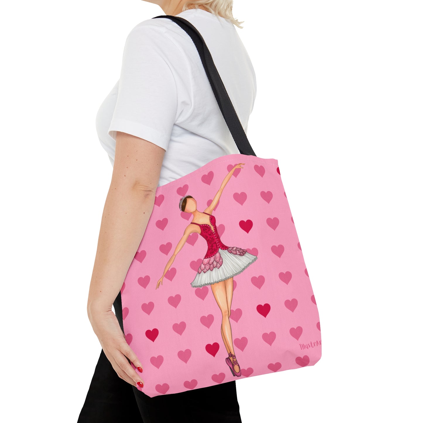 a woman carrying a pink tote bag with a ballerina on it