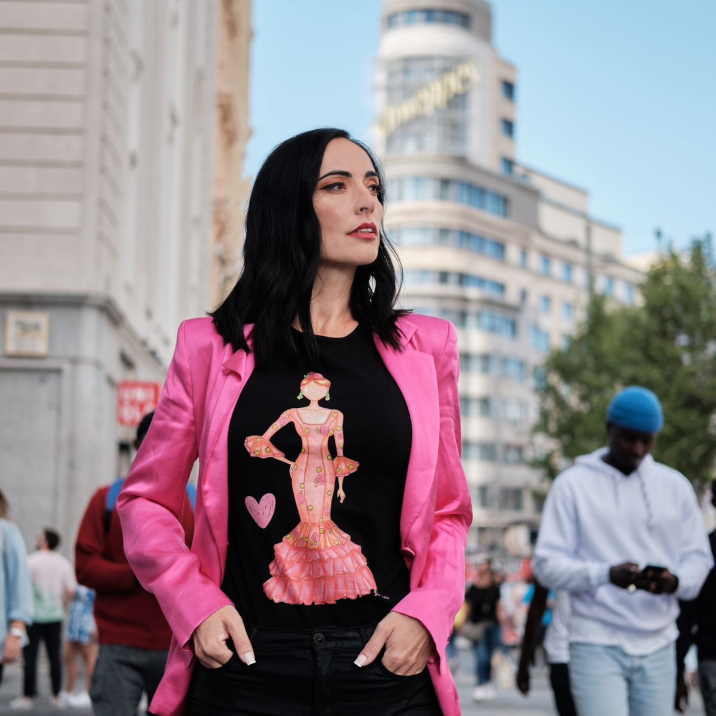 una mujer con una camisa negra y una chaqueta rosa