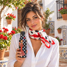 Mujer con el pañuelo de seda flamenco Pepa en un patio andaluz y la botella térmica a juego