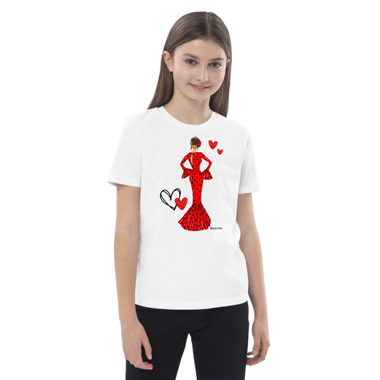 Niña feliz usando la camiseta flamenca de algodón 100% orgánico, modelo María vestido rojo, en un entorno festivo.