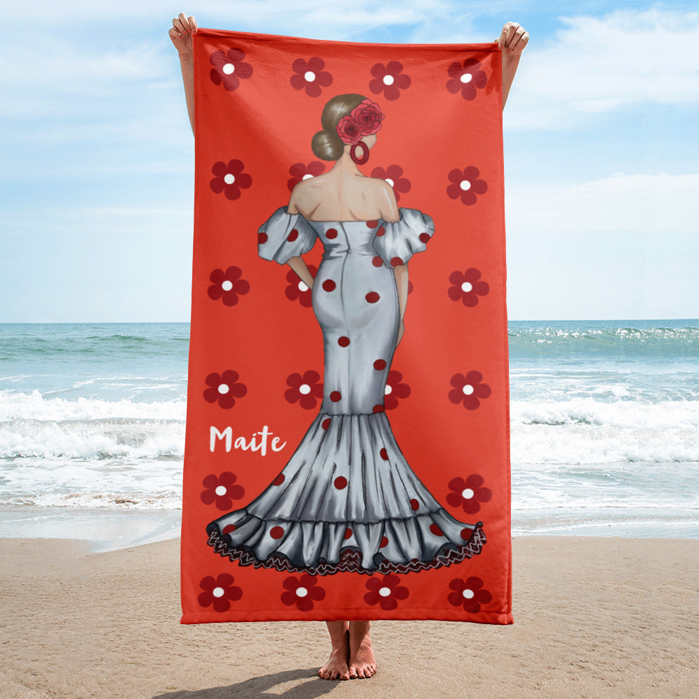 a woman standing on a beach holding a towel