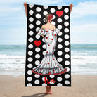 a woman standing on a beach holding a polka dot towel