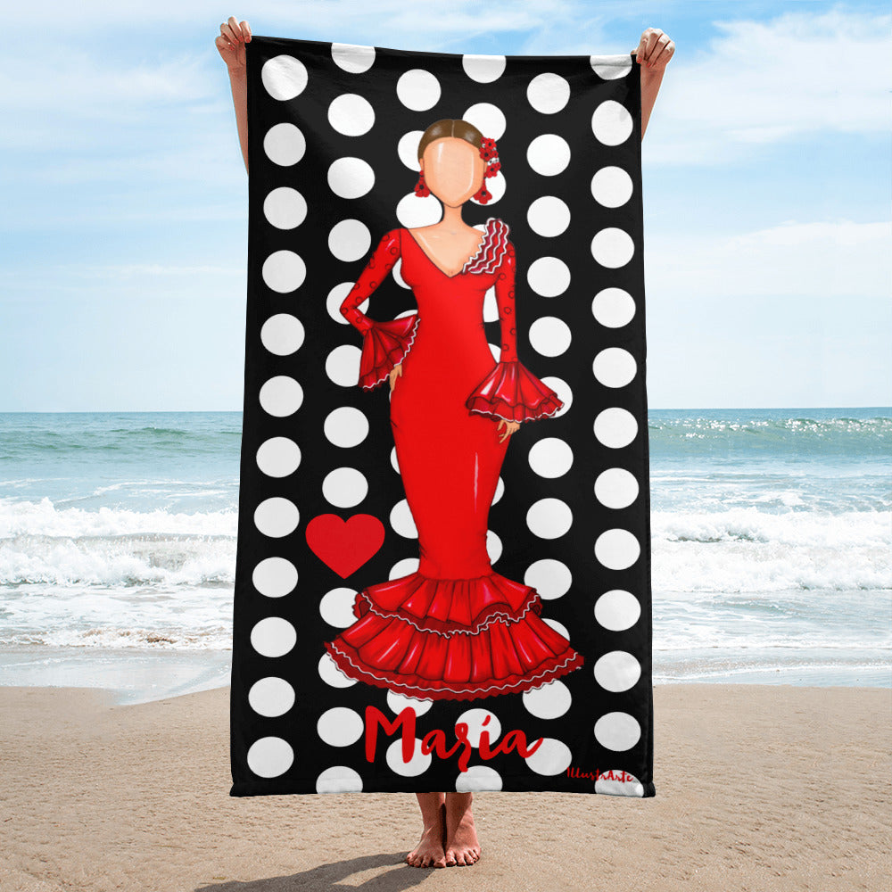 una mujer con un vestido rojo sosteniendo una toalla de playa de lunares en blanco y negro