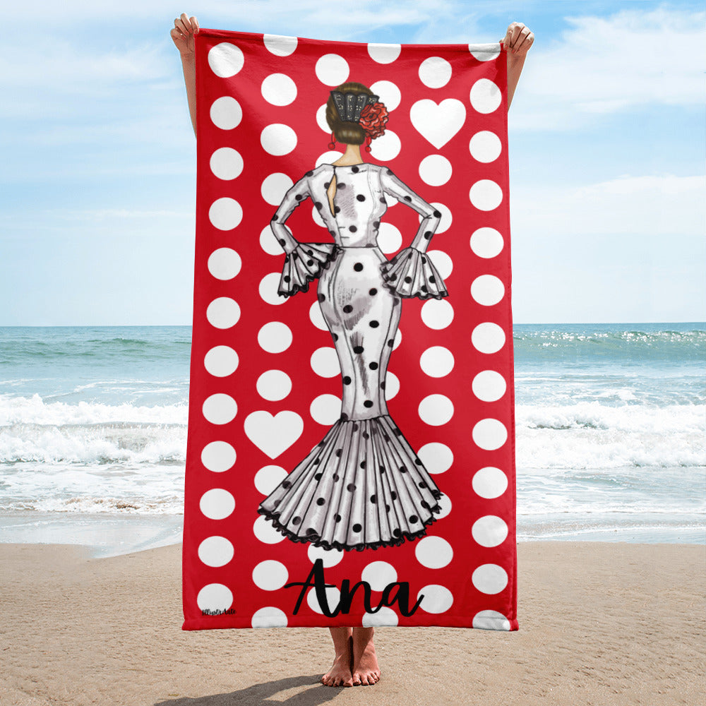 a woman standing on a beach holding a polka dot towel