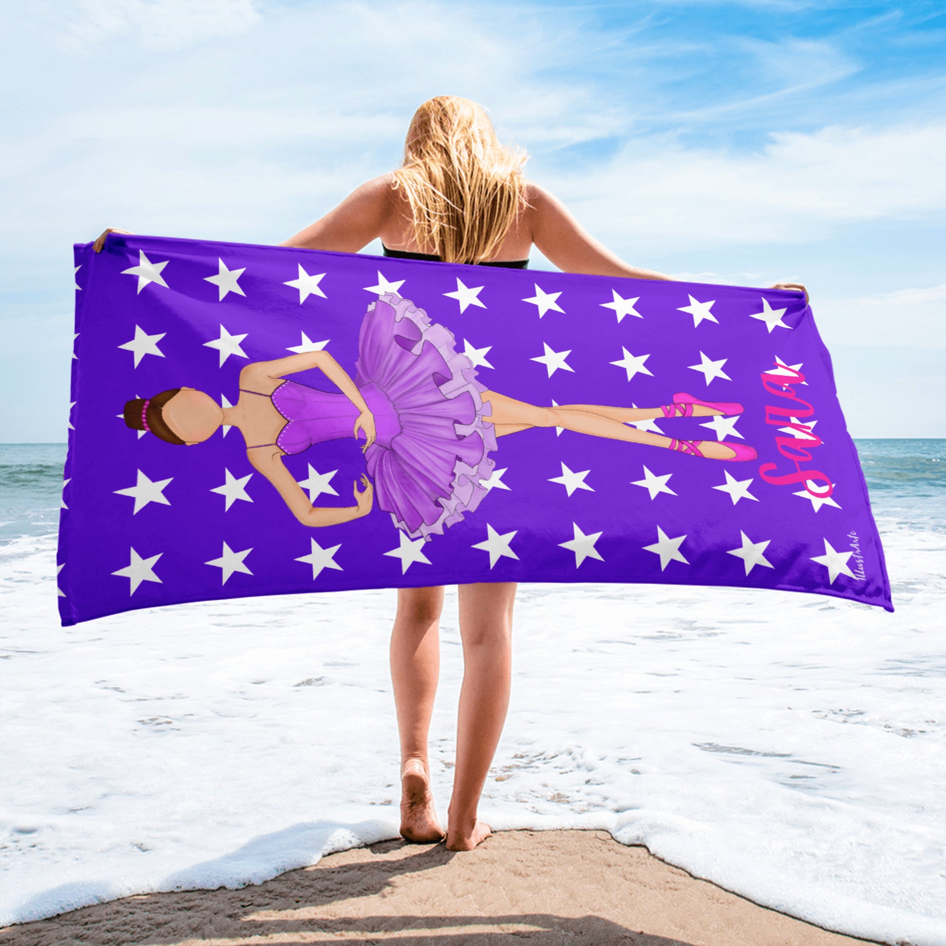 a woman holding a purple towel with a picture of a ballerina on it