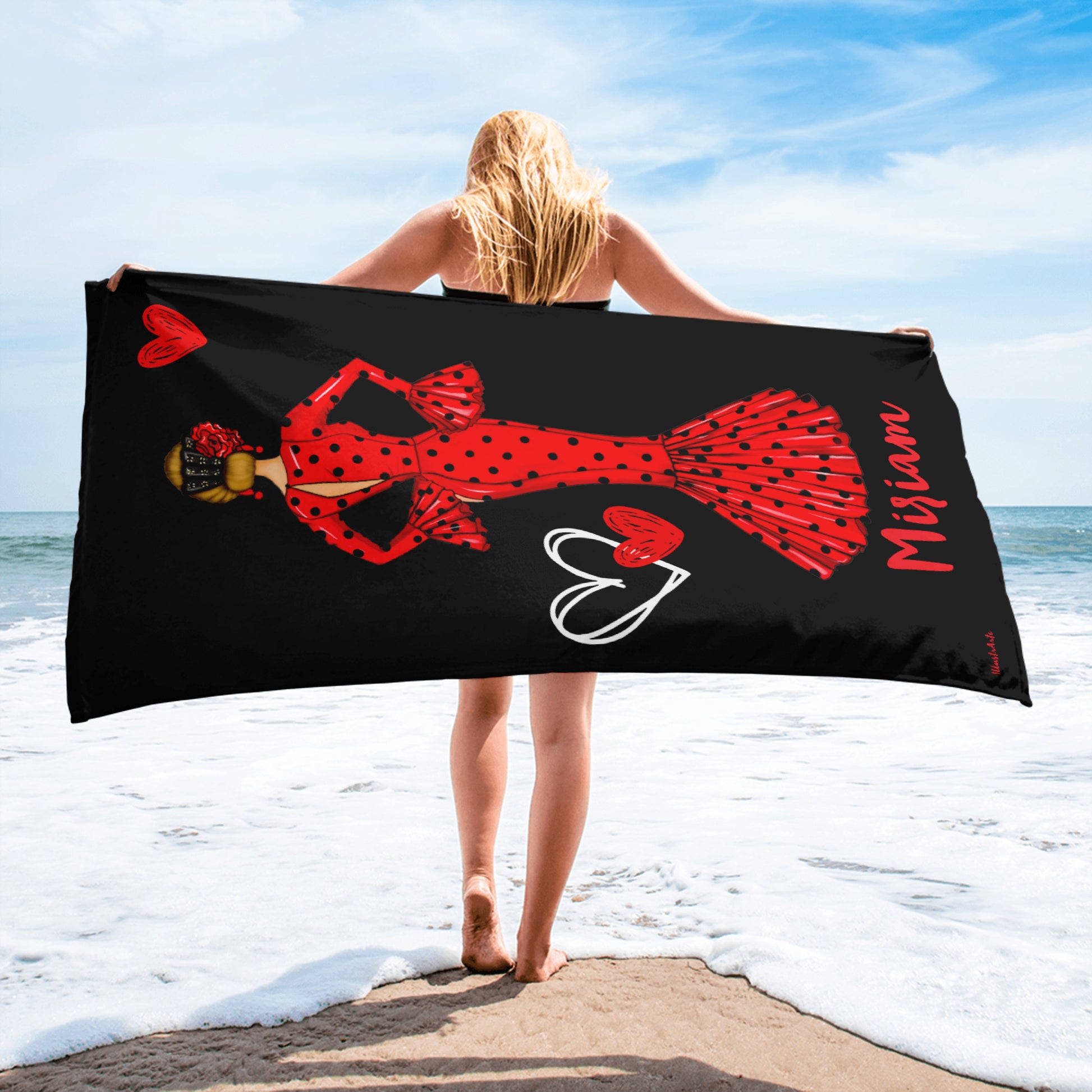 a woman standing on the beach holding a towel