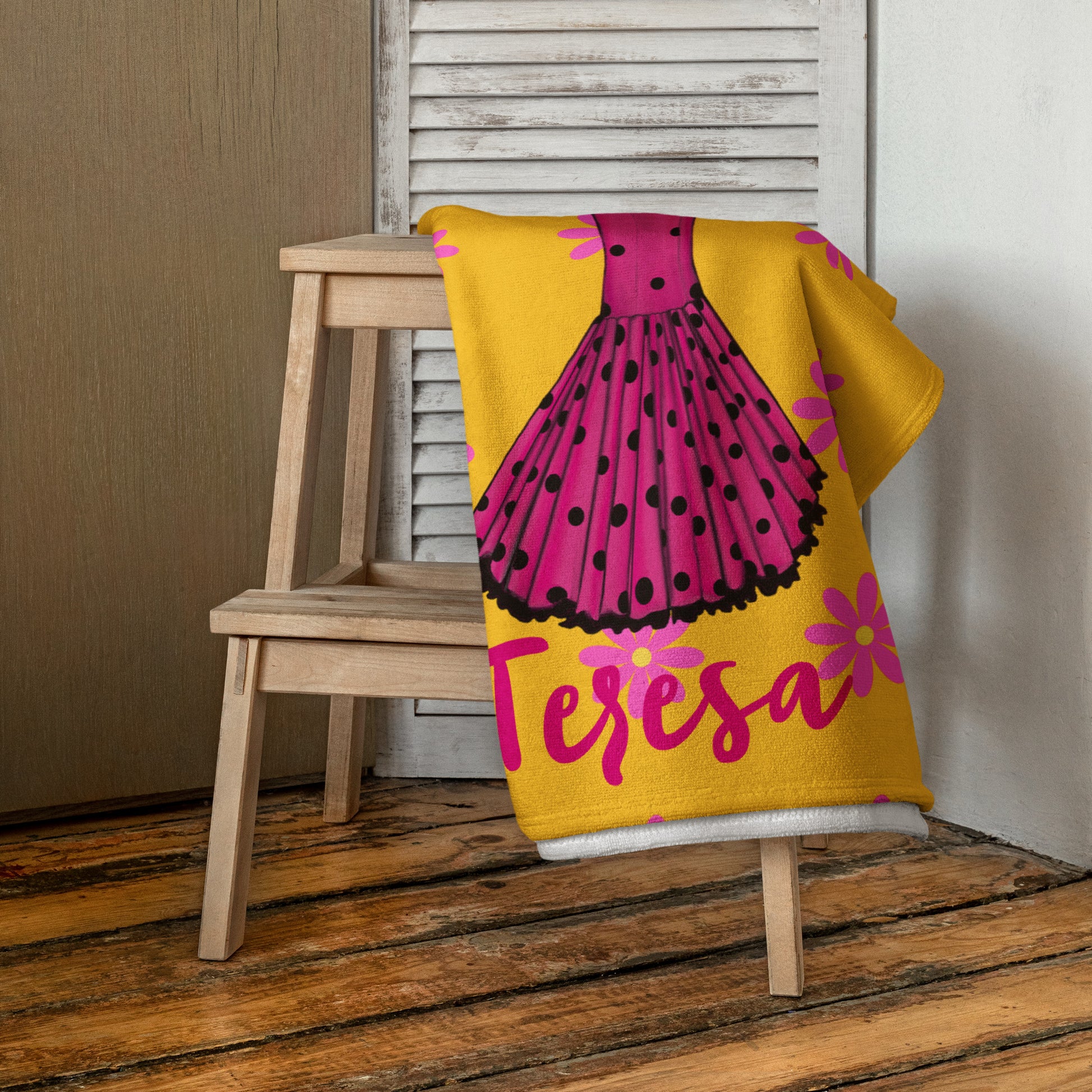 una manta amarilla y rosa con un vestido sobre ella