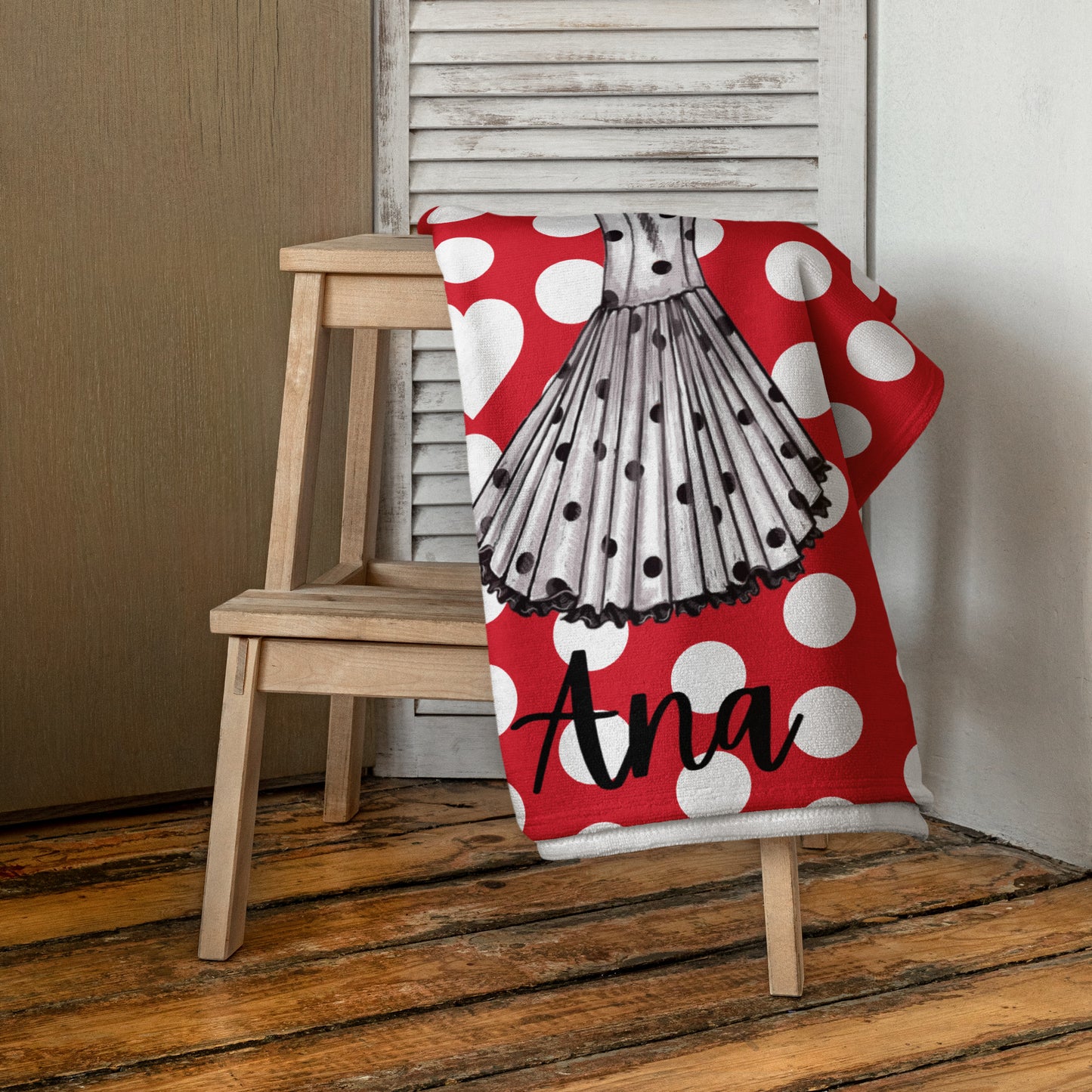 a red and white polka dot chair with a personalized beach towel