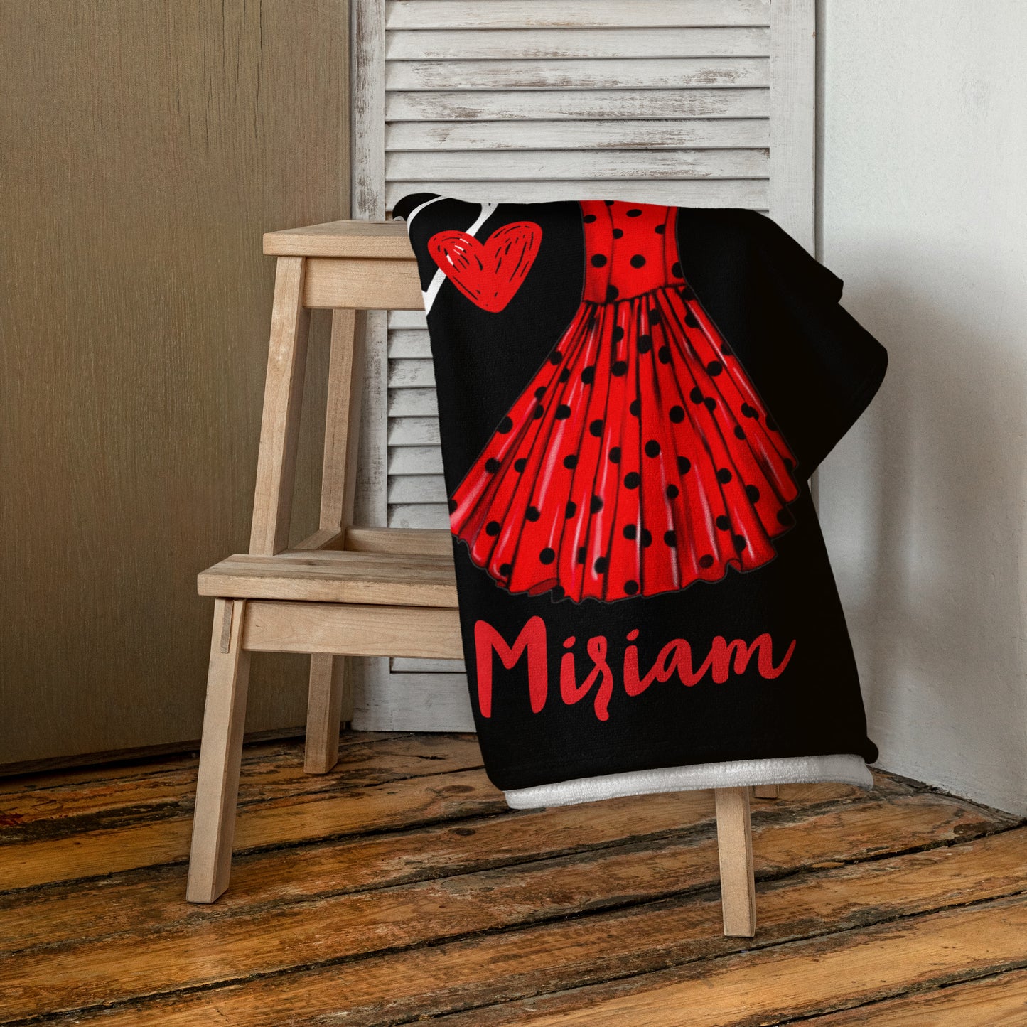 a black and red blanket sitting on top of a wooden chair